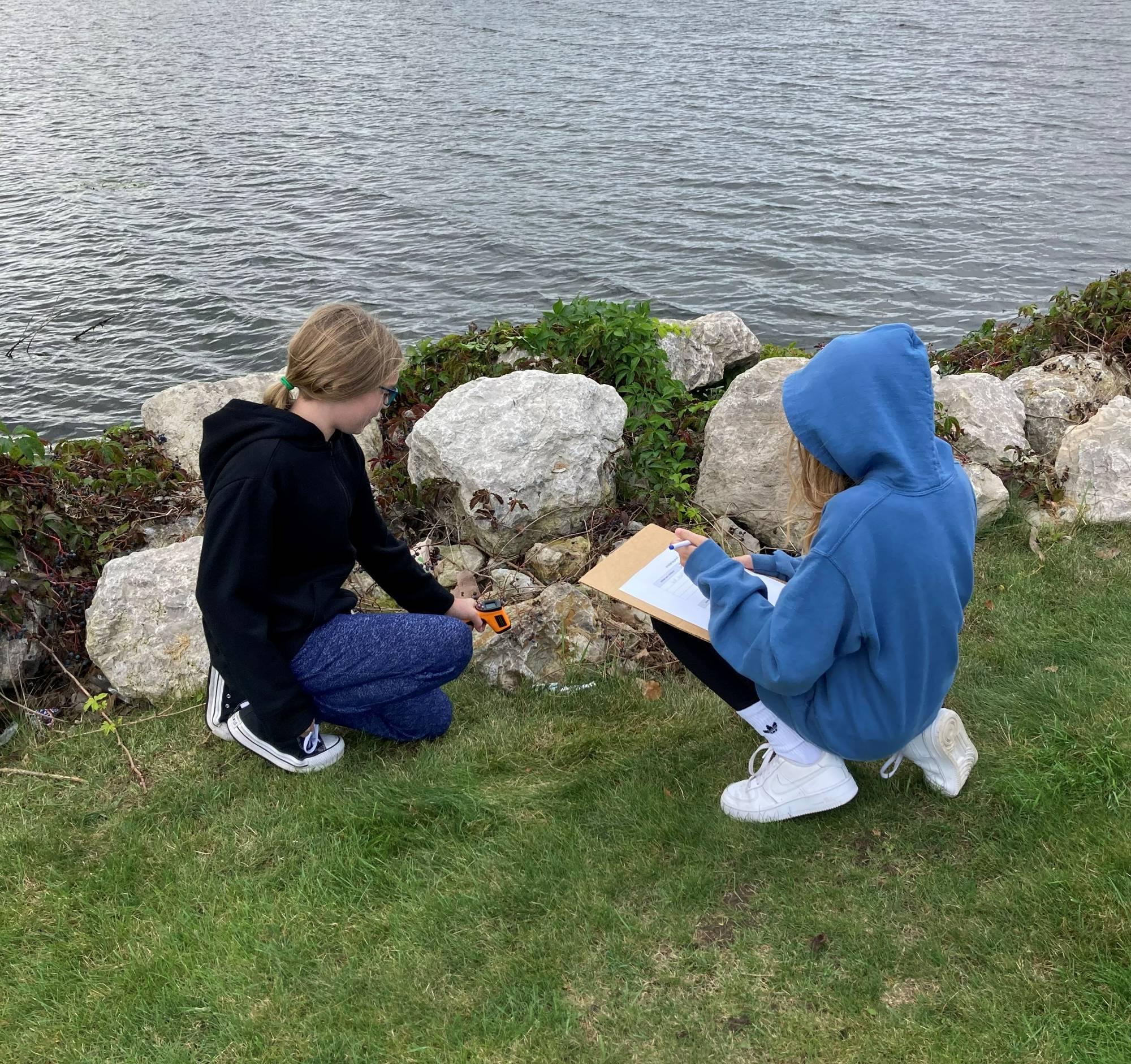 Students gather measurements on the shore of Muskegon Lake